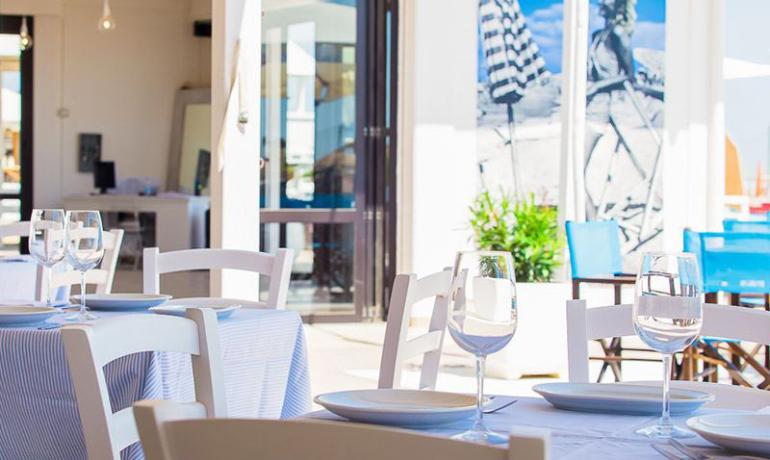 Ristorante luminoso con tavoli apparecchiati e decorazioni moderne.