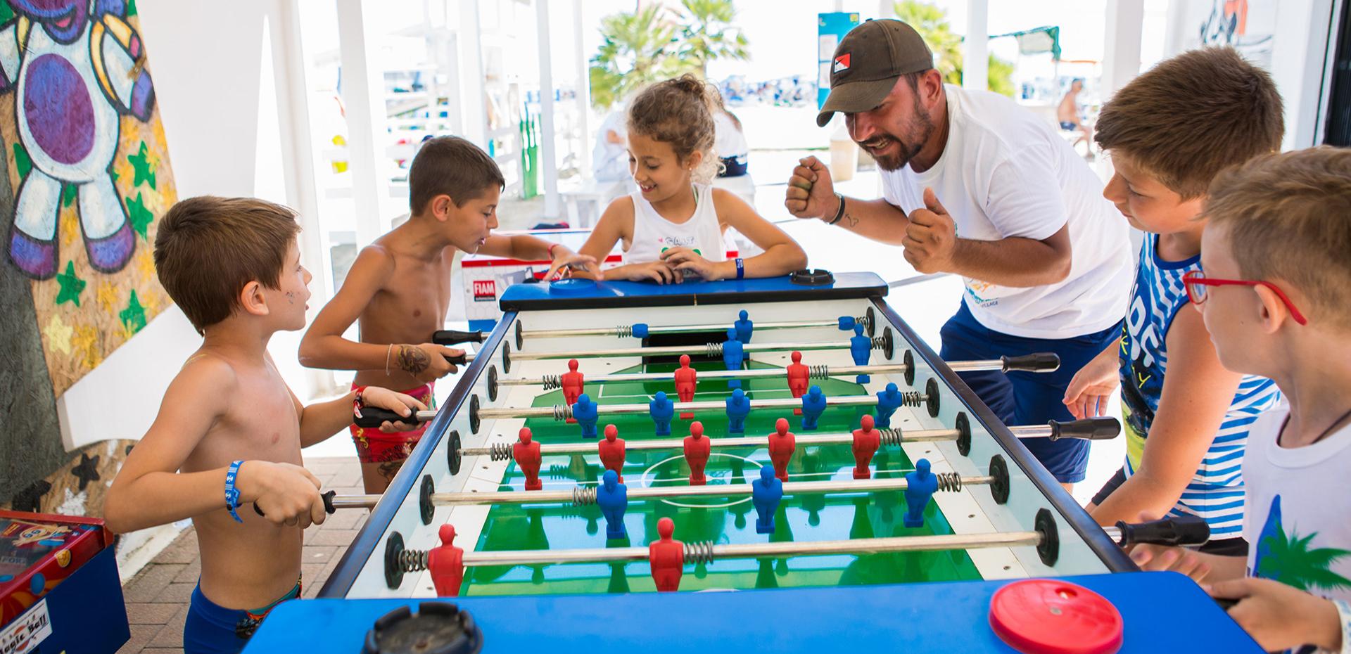 Area giochi per bambini con scivolo giallo e recinto colorato.